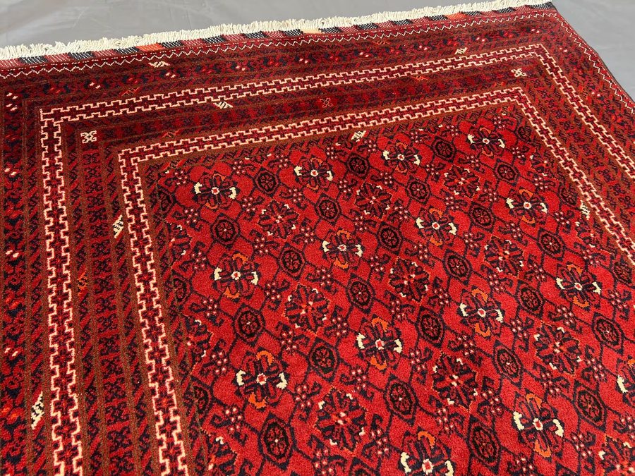 Afghan Bokhara rug — deep red field with navy octagonal guls