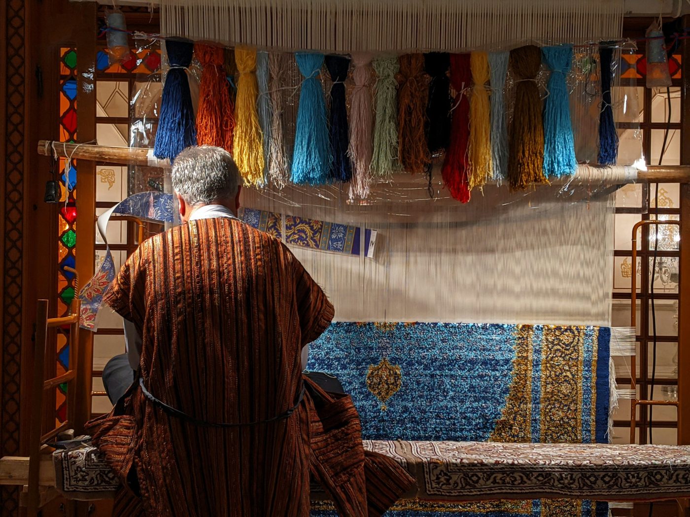 Master weaver at the loom — three weaving traditions, one studio