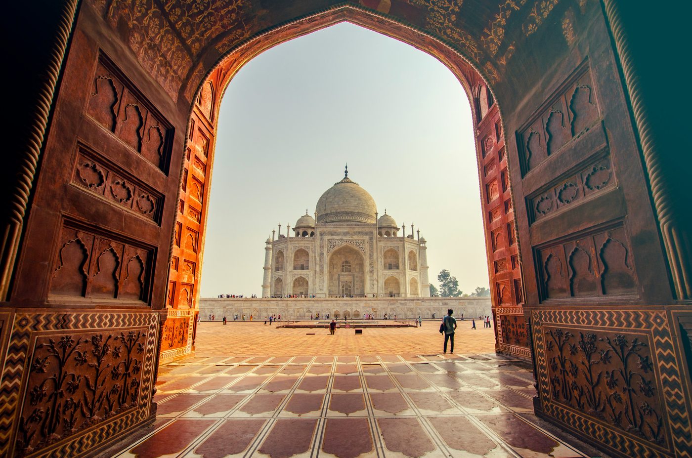 Taj Mahal seen through ornate Mughal gateway arch — Agra, India