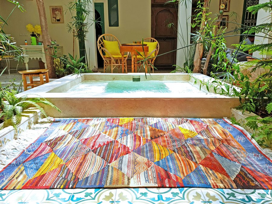 Moroccan kilim flat-weave rug in riad courtyard setting