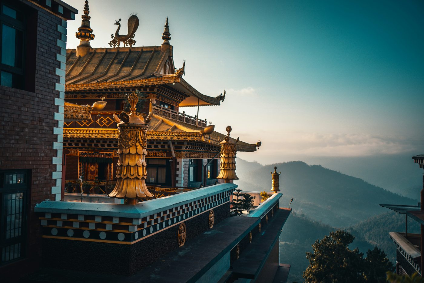 Golden Buddhist monastery temple with ornate carvings overlooking misty Himalayan mountains — Nepal