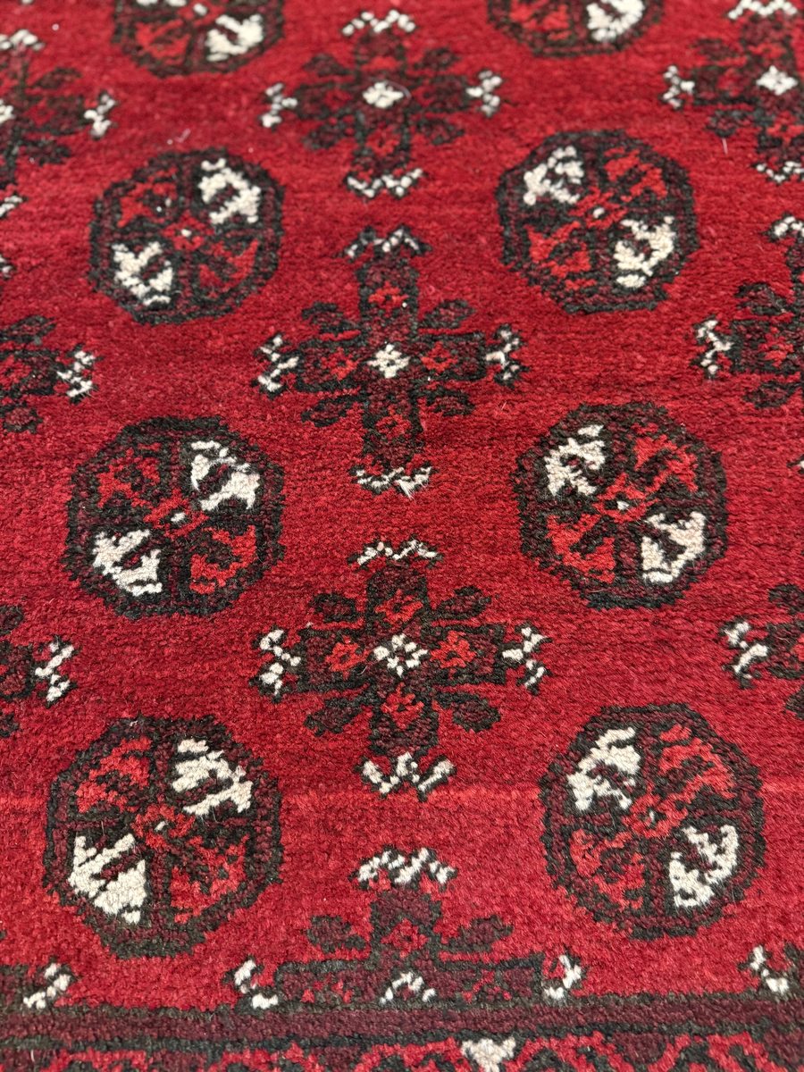 Pakistani Bokhara rug — deep red field with black and ivory gul repeat
