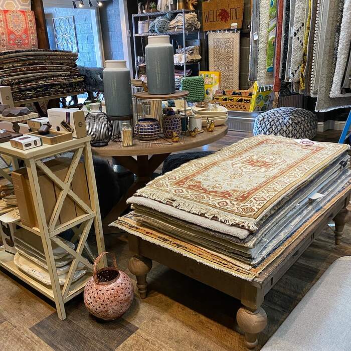A pink, navy and cream geometric rug draped over a bench