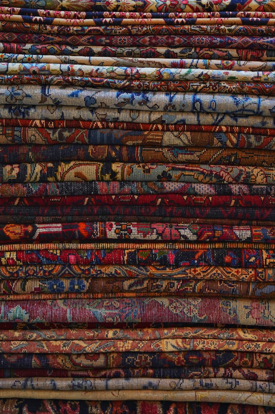 A stack of handwoven geometric rugs