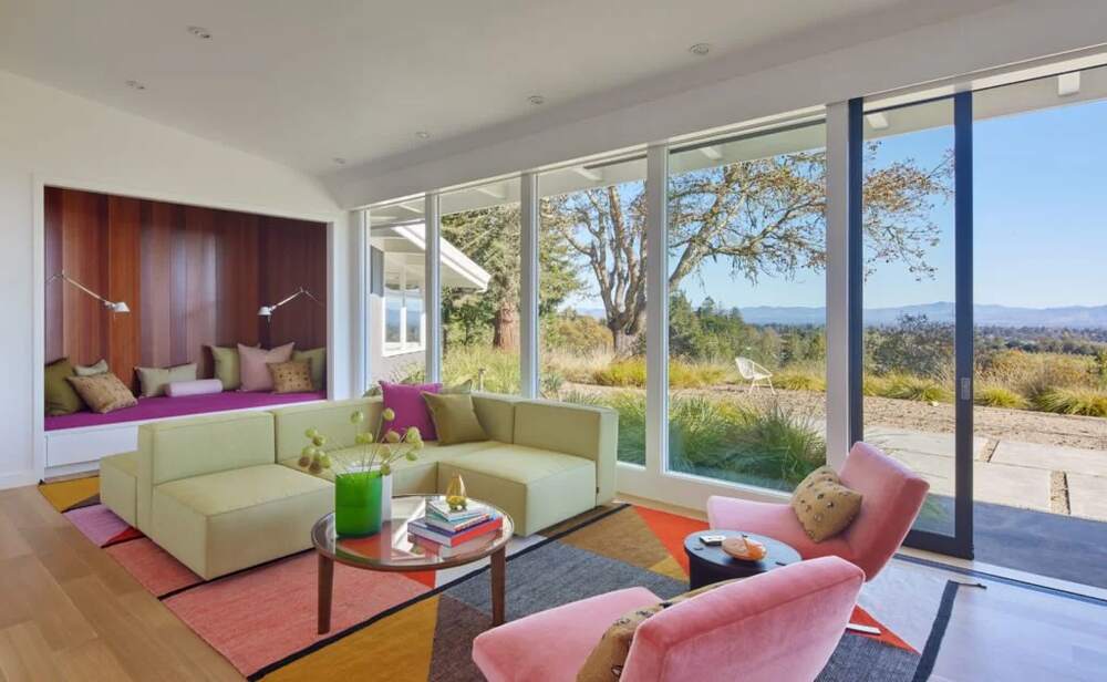 A bright modern living room anchored by a colorful rug